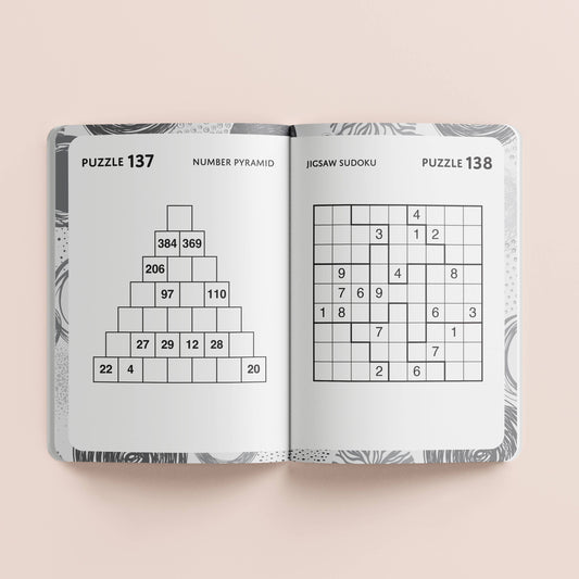 Open book with Sudoku puzzles on a light beige background