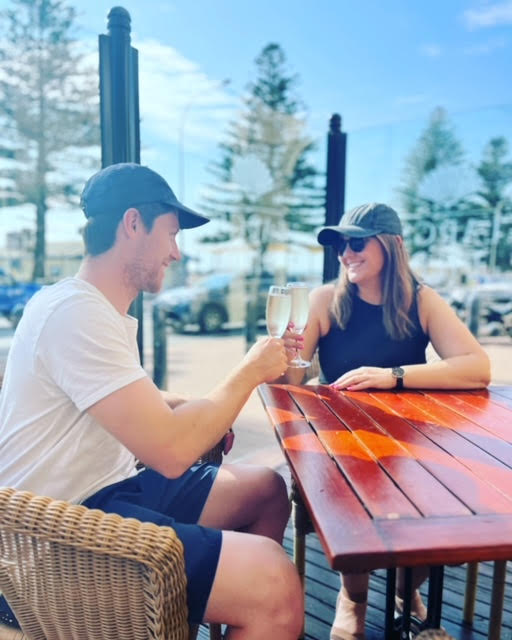 Girl wearing black cap enjoying a champagne