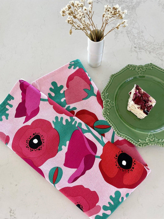 Floral-patterned towel on a table with a green plate and dessert