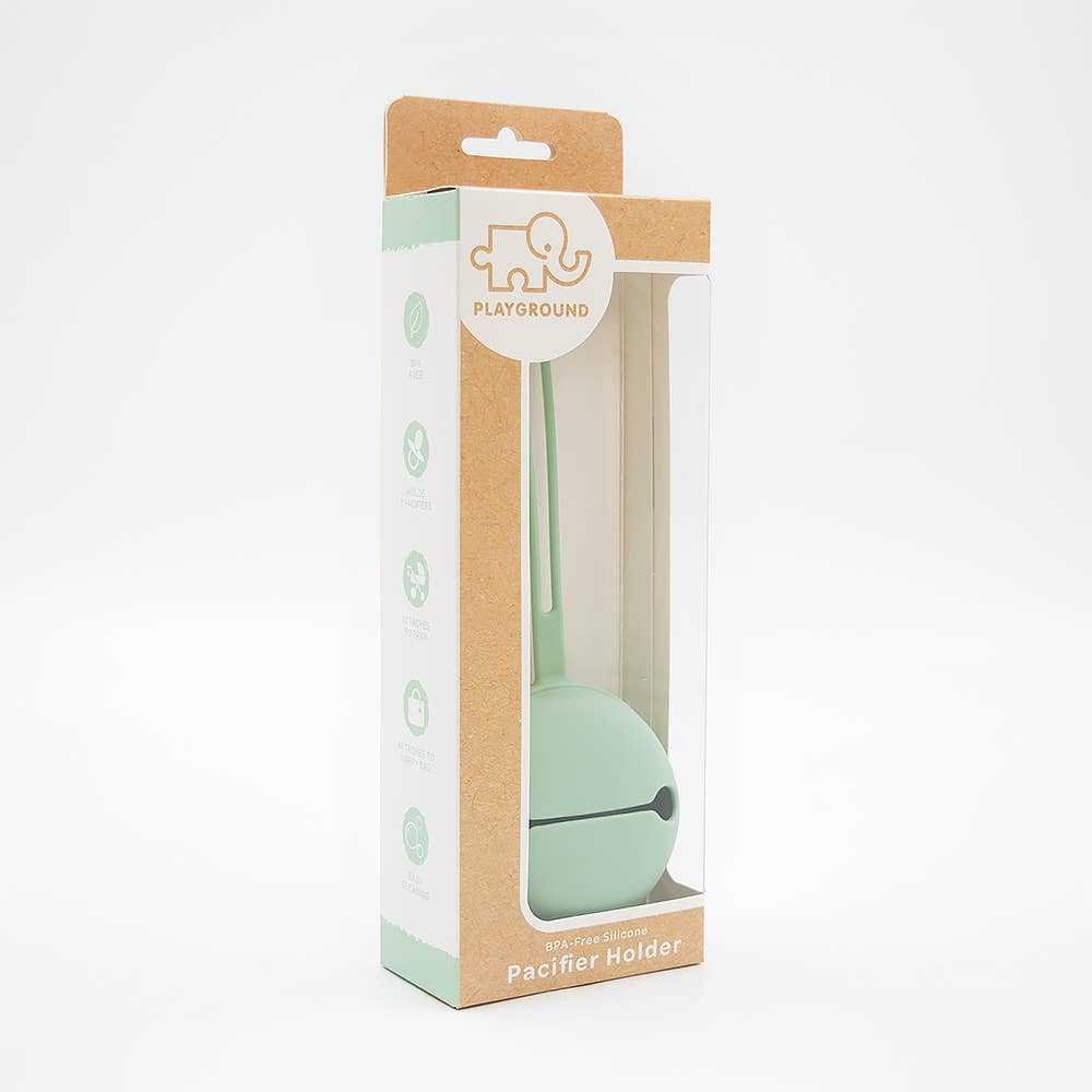 Mint green pacifier holder in a clear plastic window on a cardboard box with 'Playground' branding.