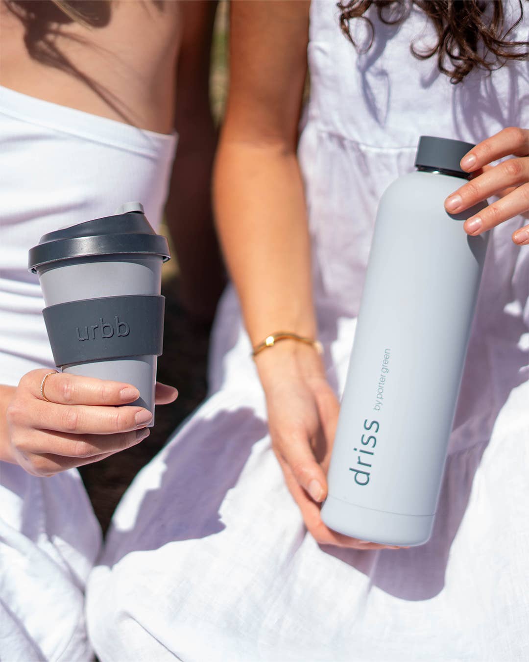 Two people holding a coffee cup and water bottle with 'driss' branding.