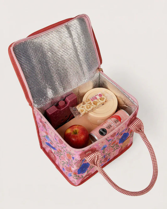 Pink floral insulated lunch bag with food items on a white background
