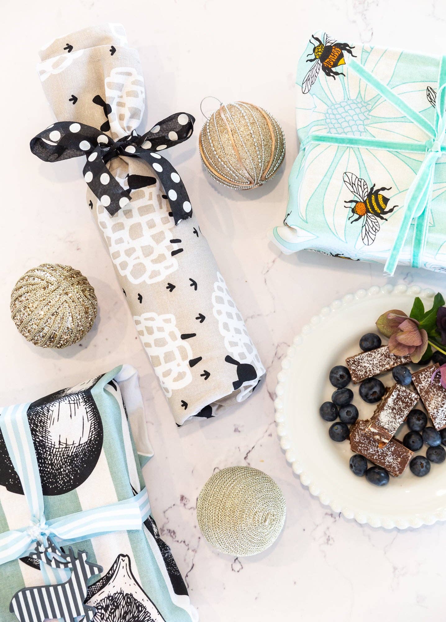 Assorted baby items including a bib, teether, and cookies on a light surface.