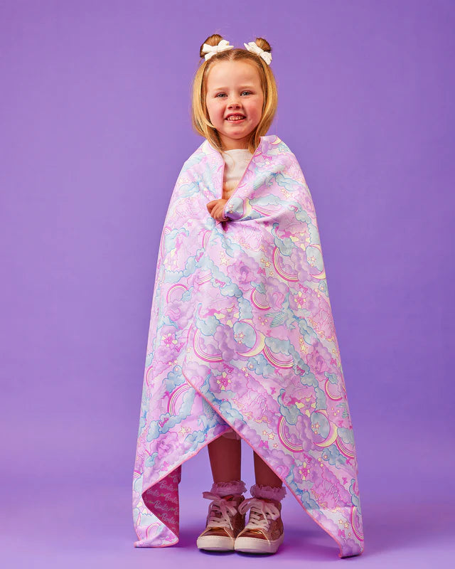 Child wrapped in a colorful barbie beach towel with a purple background