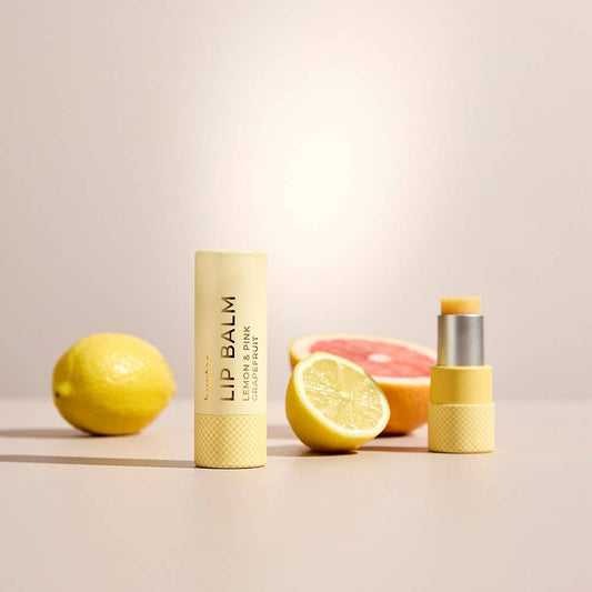 Lip balm with lemon and grapefruit on a neutral background