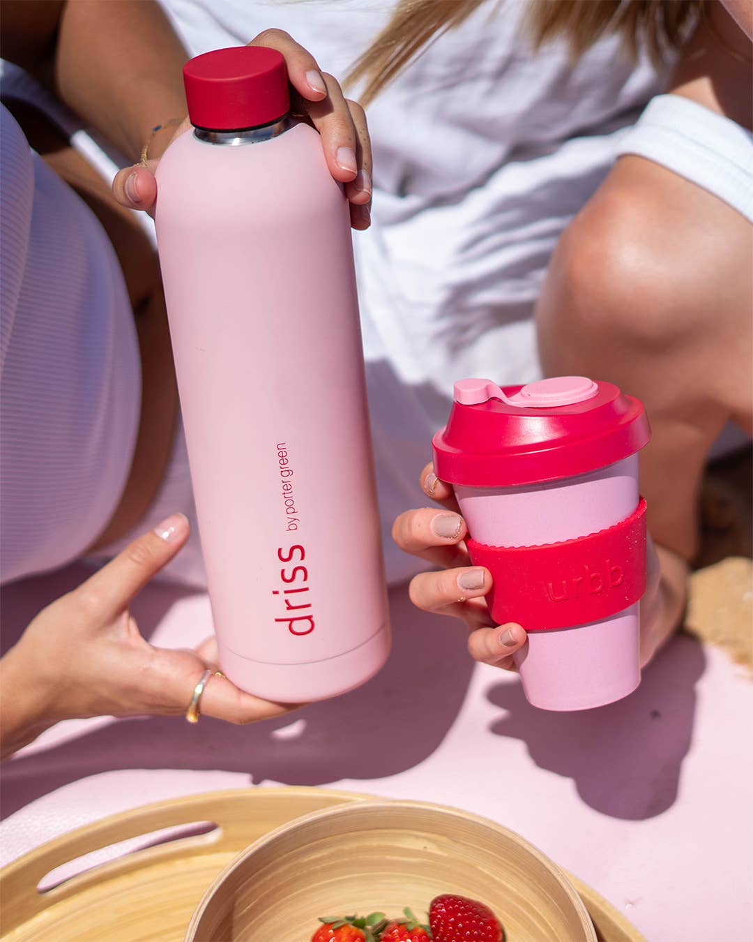 Pink and red reusable coffee cup with 'urbb' branding on a white background