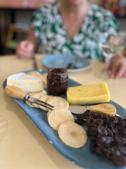 Lady behind cheese platter 