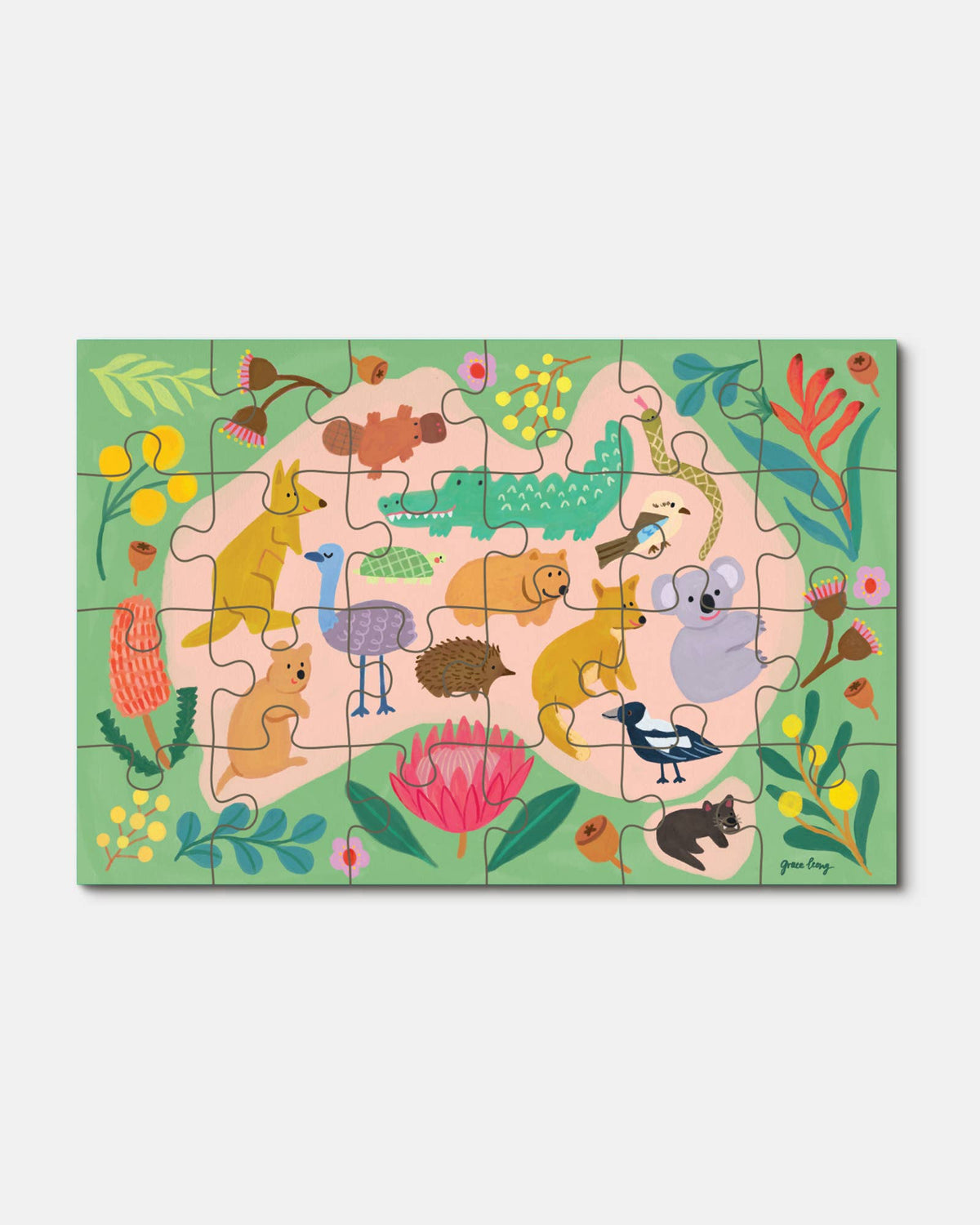 A children's jigsaw puzzle featuring a colorful Australian-themed illustration with kangaroos, koalas, a crocodile, a bird, and tropical flowers on a light green background, shown against a plain light gray backdrop.