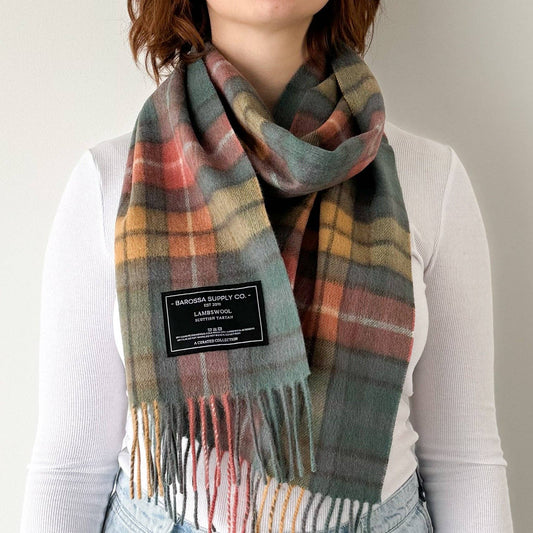Person wearing a plaid scarf with visible branding on a plain background