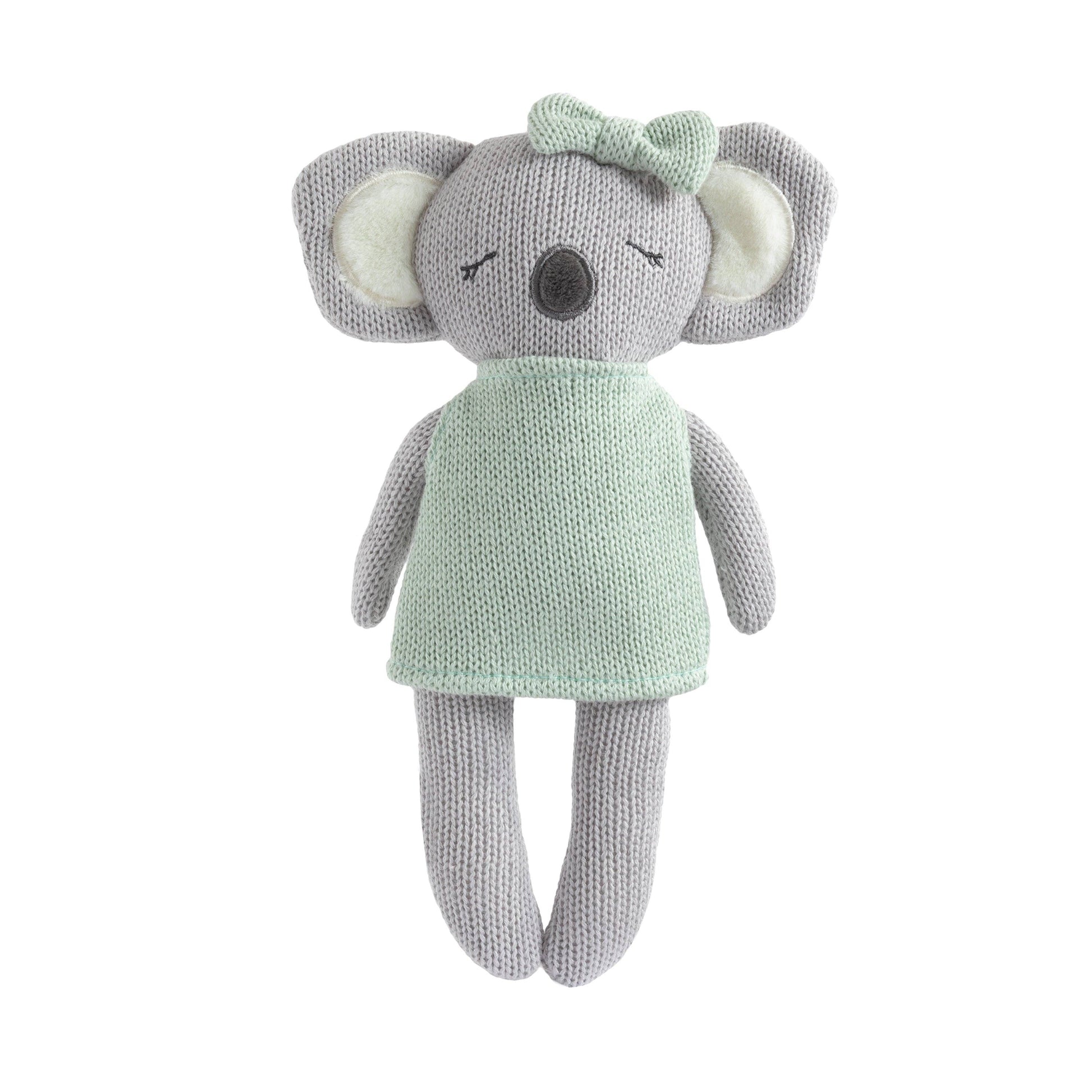 Knitted toy elephant with a green dress and bow on a white background