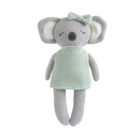 Knitted toy elephant with a green dress and bow on a white background
