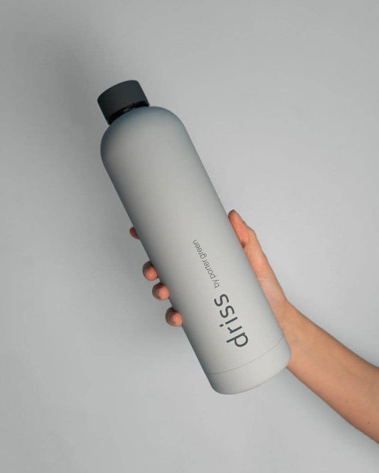 Person holding a gray water bottle with 'driss' branding on a light gray background