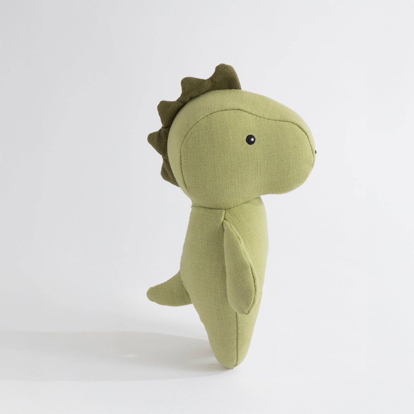 Green dinosaur plush toy on a white background