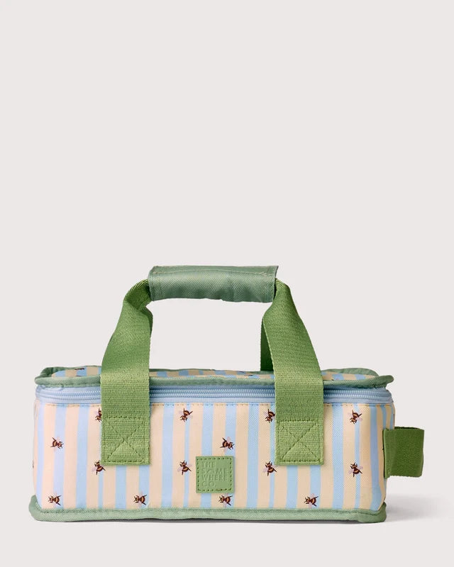 A rectangular insulated lunch bag with a light blue and cream vertical stripe pattern, decorated with small embroidered bees, featuring green fabric handles and trim, set against a solid light gray background.