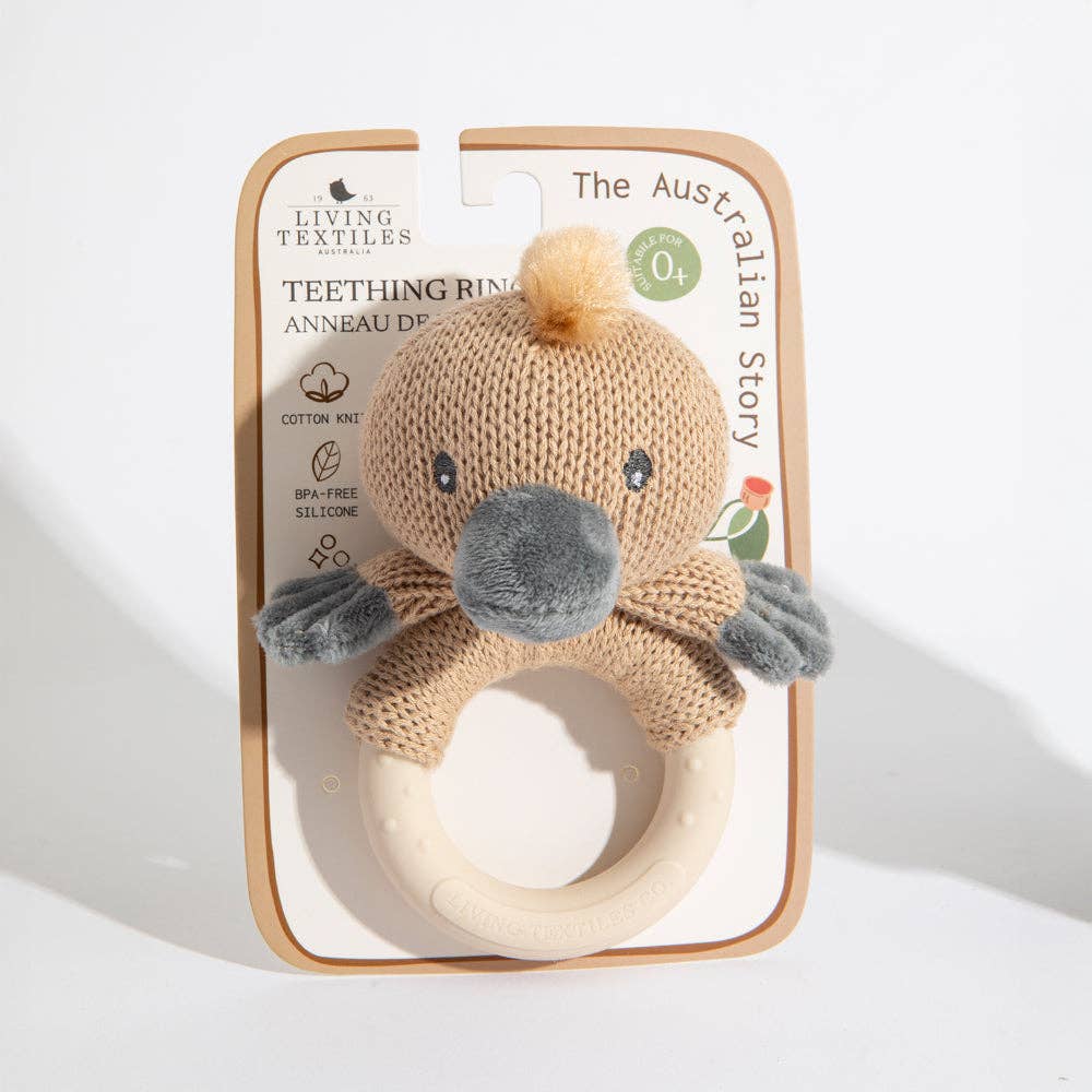Knitted teething ring with Penny the Platypus design in packaging on a white background