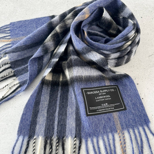 Blue plaid scarf with a label on a light gray background