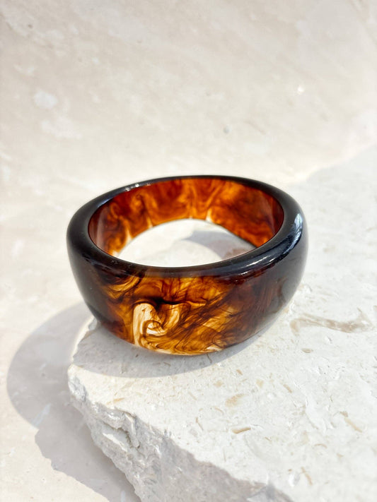 Tortoiseshell bangle on a light stone surface