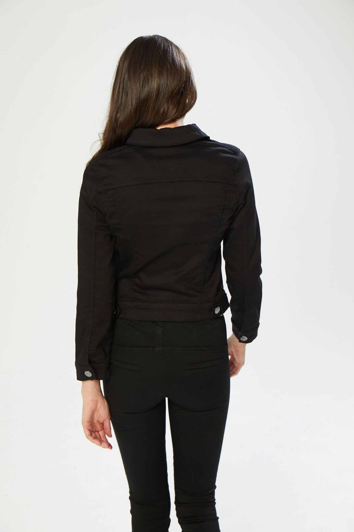 Person wearing a black jacket and pants on a white background