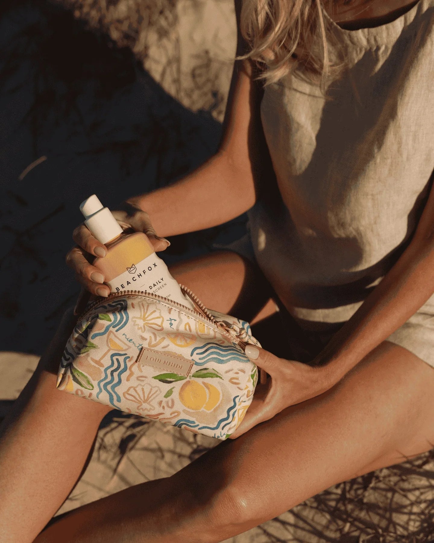 Person holding a patterned bag with a product labeled 'Bach' on a textured surface.