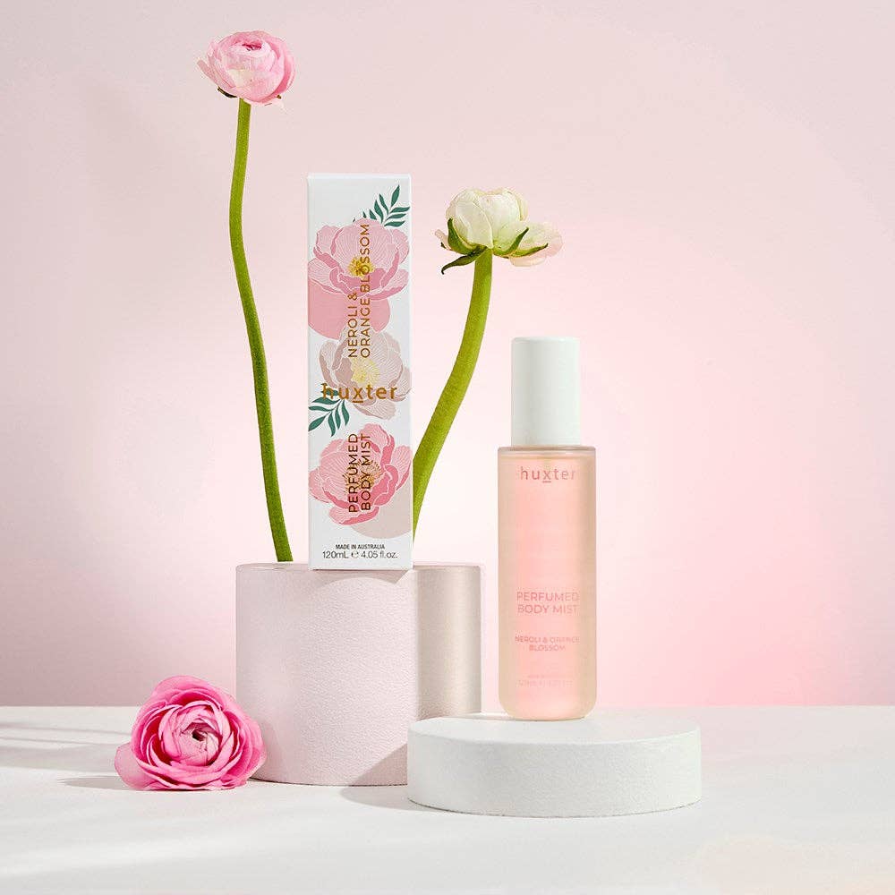 Nuxe body care product with flowers on a pink background