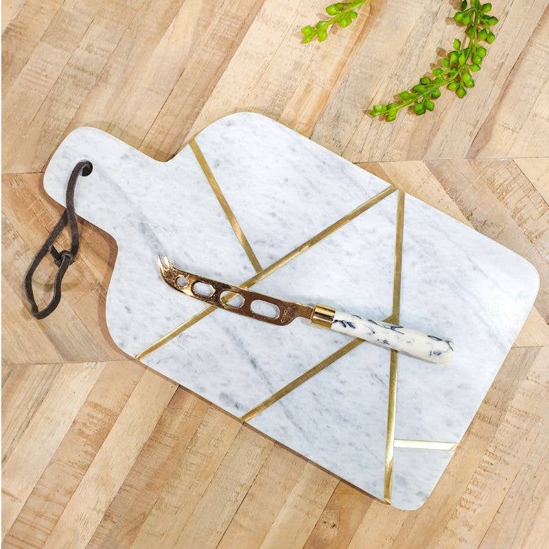 Marble cutting board with gold accents on a wooden surface