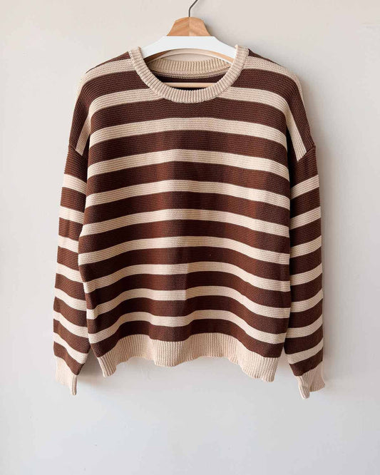 Brown and beige striped sweater on a hanger against a white background