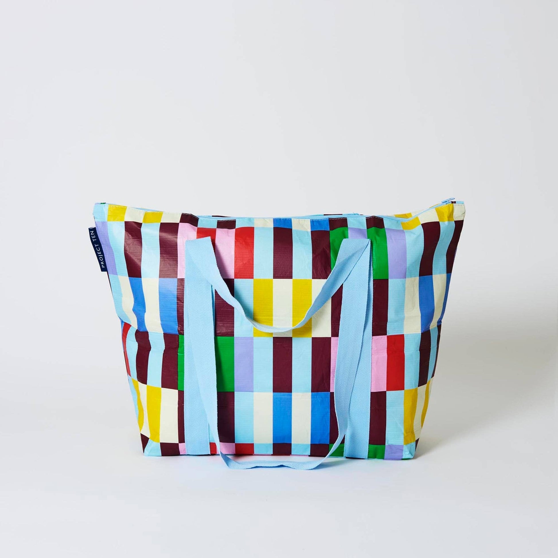 Colorful checkered bag with a blue handle on a white background