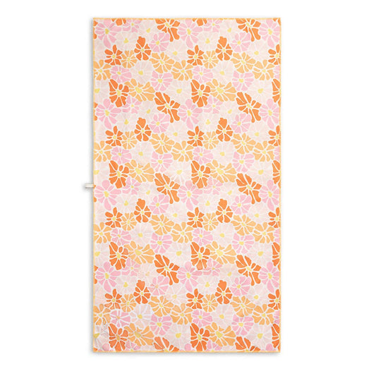 Floral patterned beach towel with pink and orange flowers on a white background