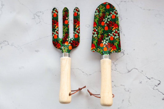 Two garden tools with floral patterns on a marble surface