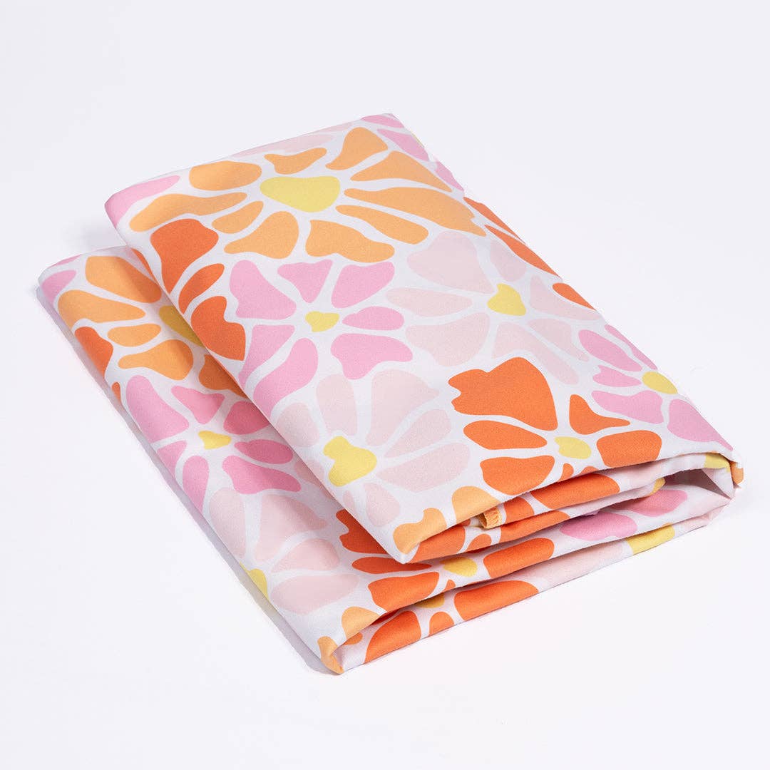 Floral-patterned fabric with pink, orange, and yellow flowers on a white background
