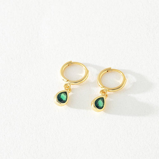 Gold hoop earrings with green teardrop charms on a white background