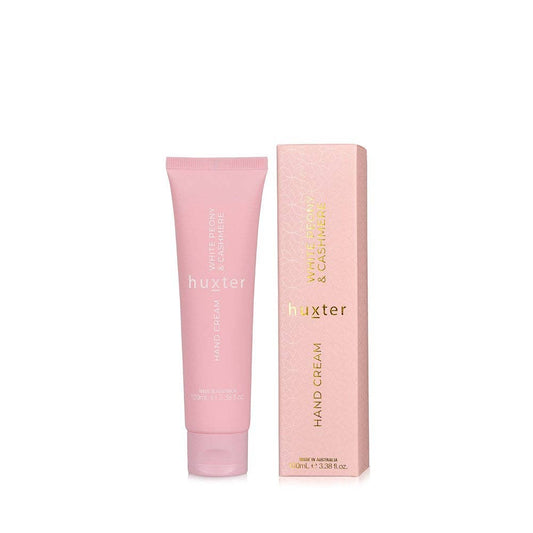 Pink hand cream tube and packaging with 'huxter' branding on a white background