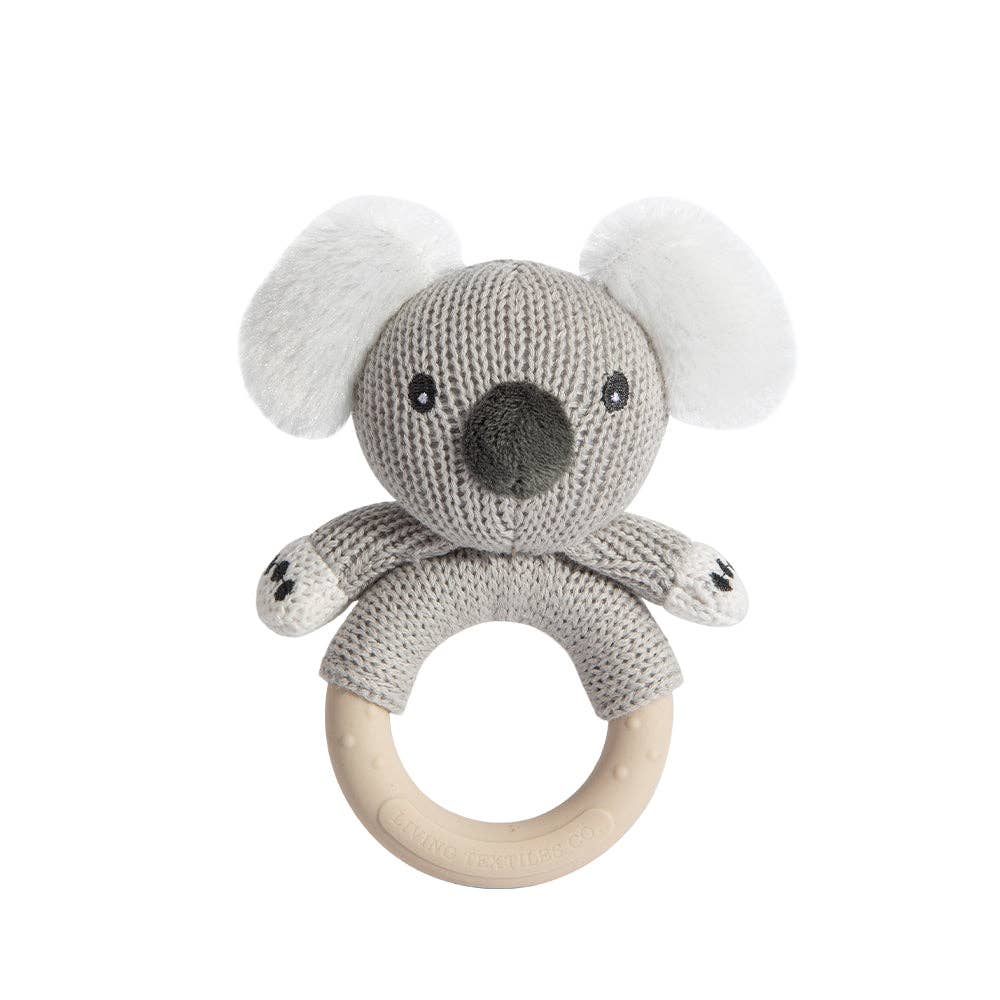 Knitted koala rattle toy with wooden ring on a white background
