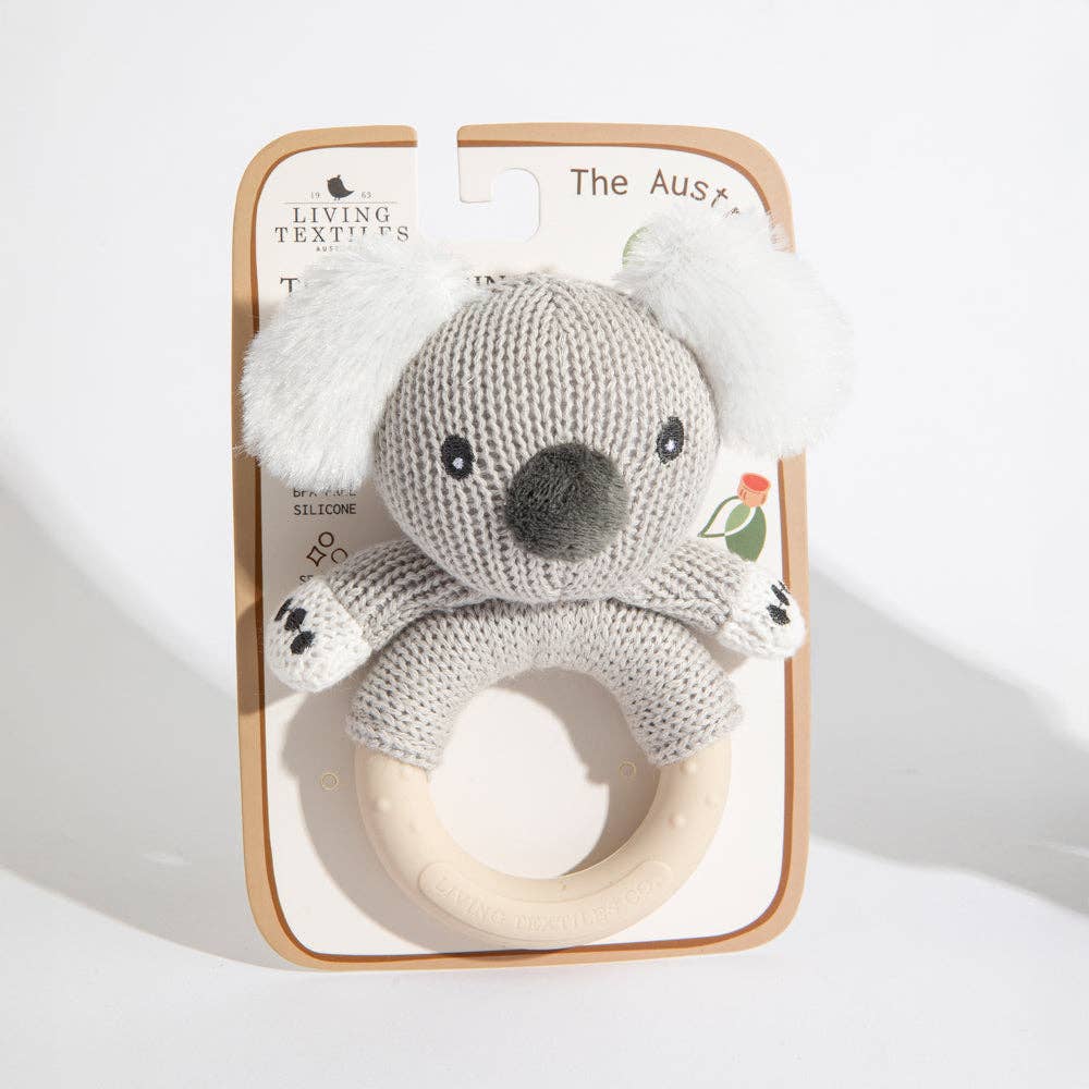 Knitted koala toy with wooden ring in packaging on a white background