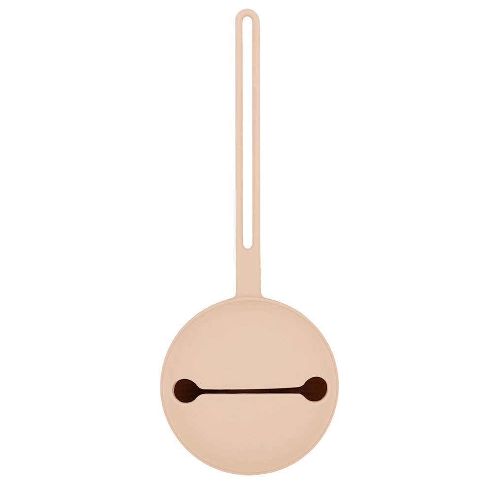 Round beige object with a dark brown line on a white background