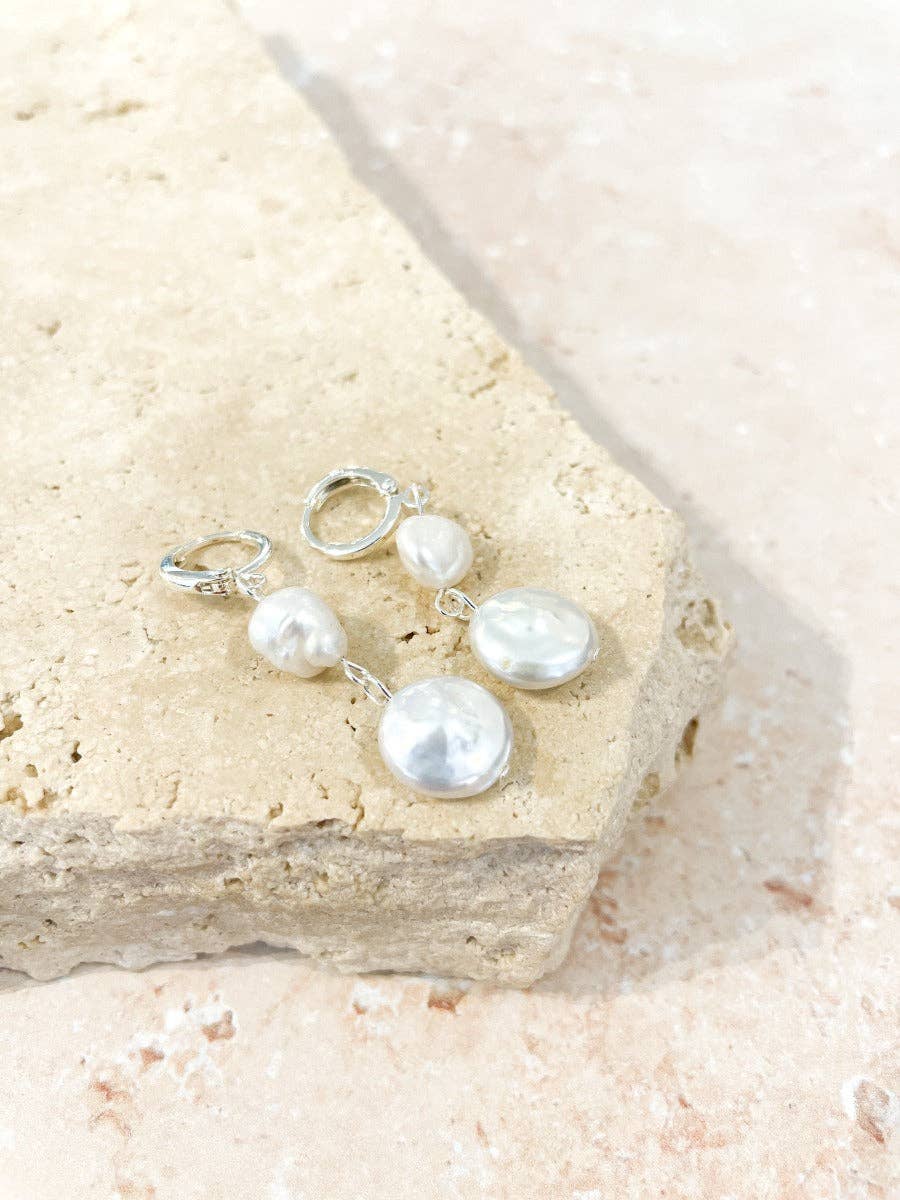 Pearl earrings on a piece of sand