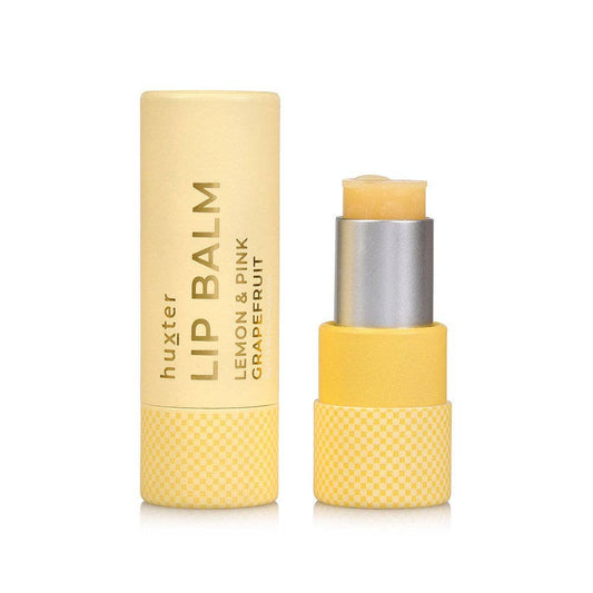 Yellow lip balm with silver cap on a white background